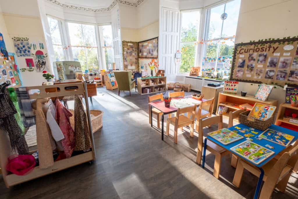 Bright and welcoming childcare classroom with colourful educational displays, reading materials, and activity tables designed for young children’s learning and play at Thrive Childcare.