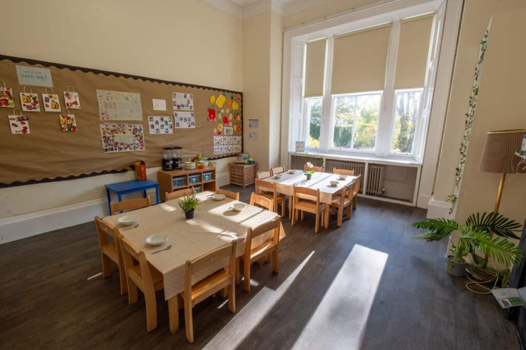 Bright and welcoming childcare dining room at Thrive Childcare, featuring child-sized tables, natural light from large windows, and colourful educational displays for a nurturing early learning environment.