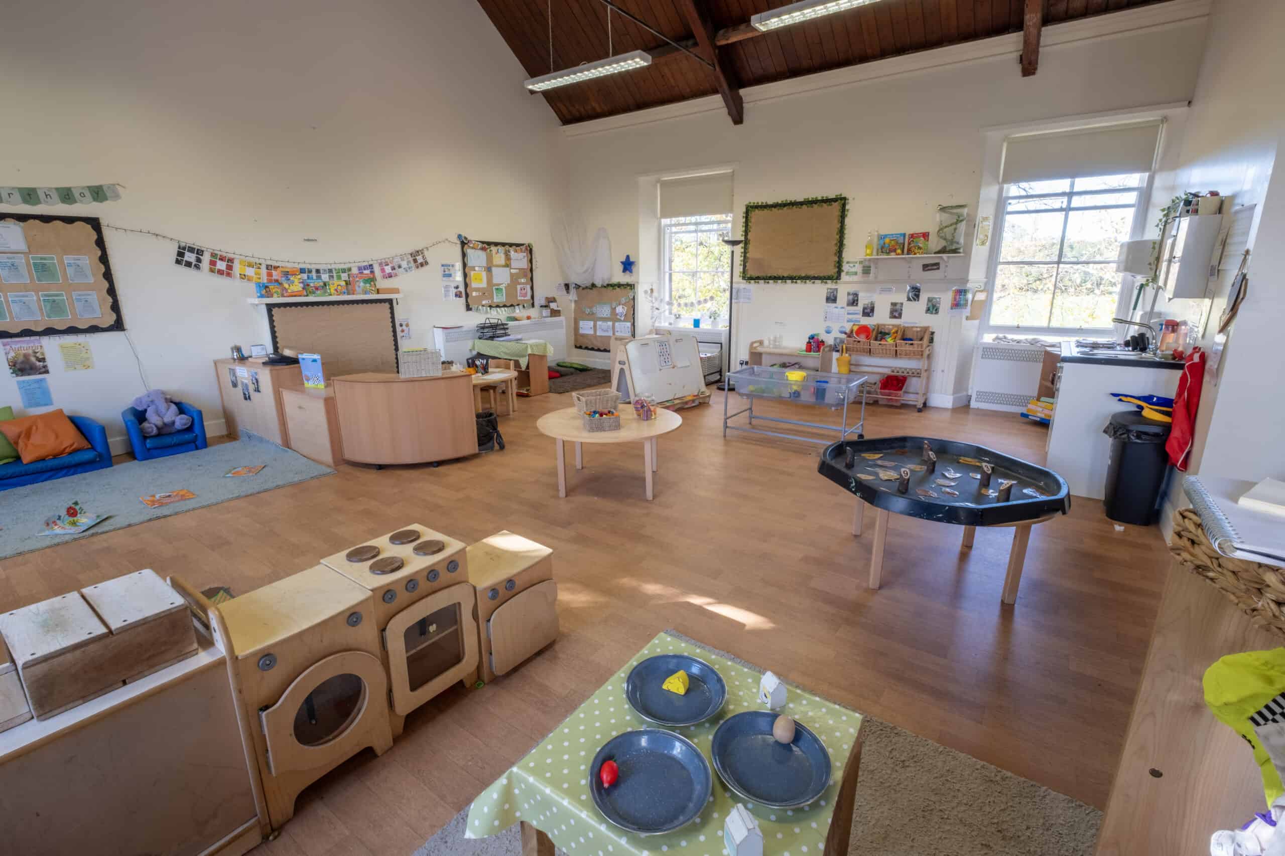 Bright, spacious indoor childcare room at Thrive Childcare with play zones, educational materials, and natural light, creating a safe and engaging environment for young children.