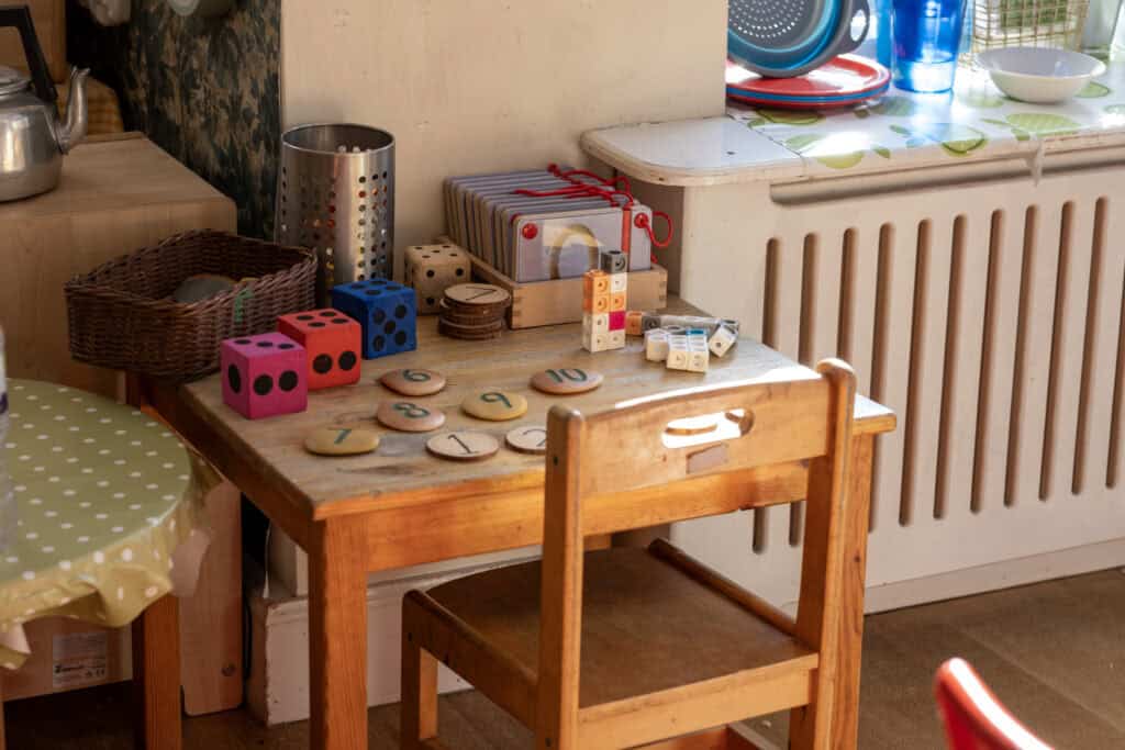 Colourful educational toys and games on a wooden table at Thrive Childcare, promoting early childhood development and learning in a nurturing environment.