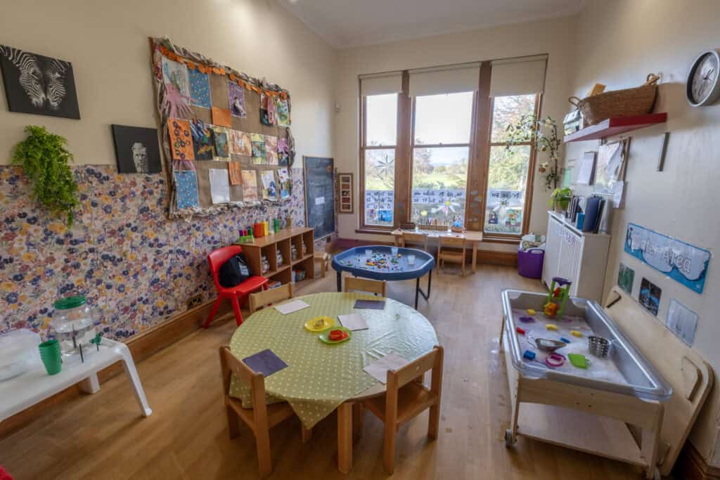 Bright nursery classroom at Thrive Childcare with learning and play areas, colourful decorations, and large windows providing natural light for early childhood development.