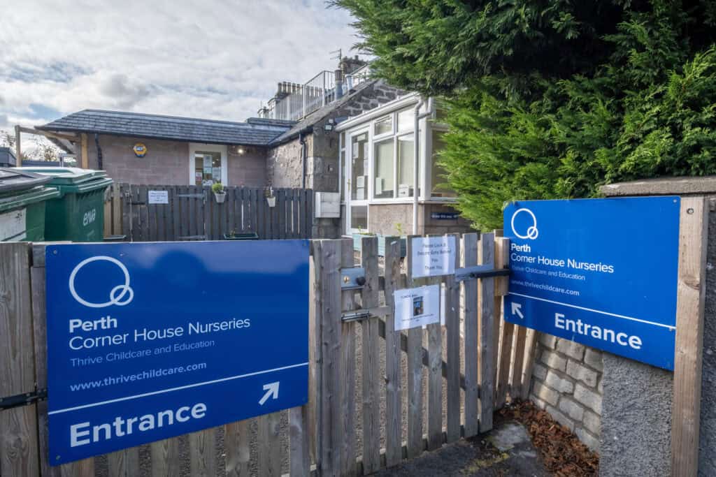 Bright blue Perth Corner House Nurseries entrance signs at the nursery gate, welcoming families to Thrive Childcare and Education in a peaceful, child-friendly environment in Perth, Scotland.