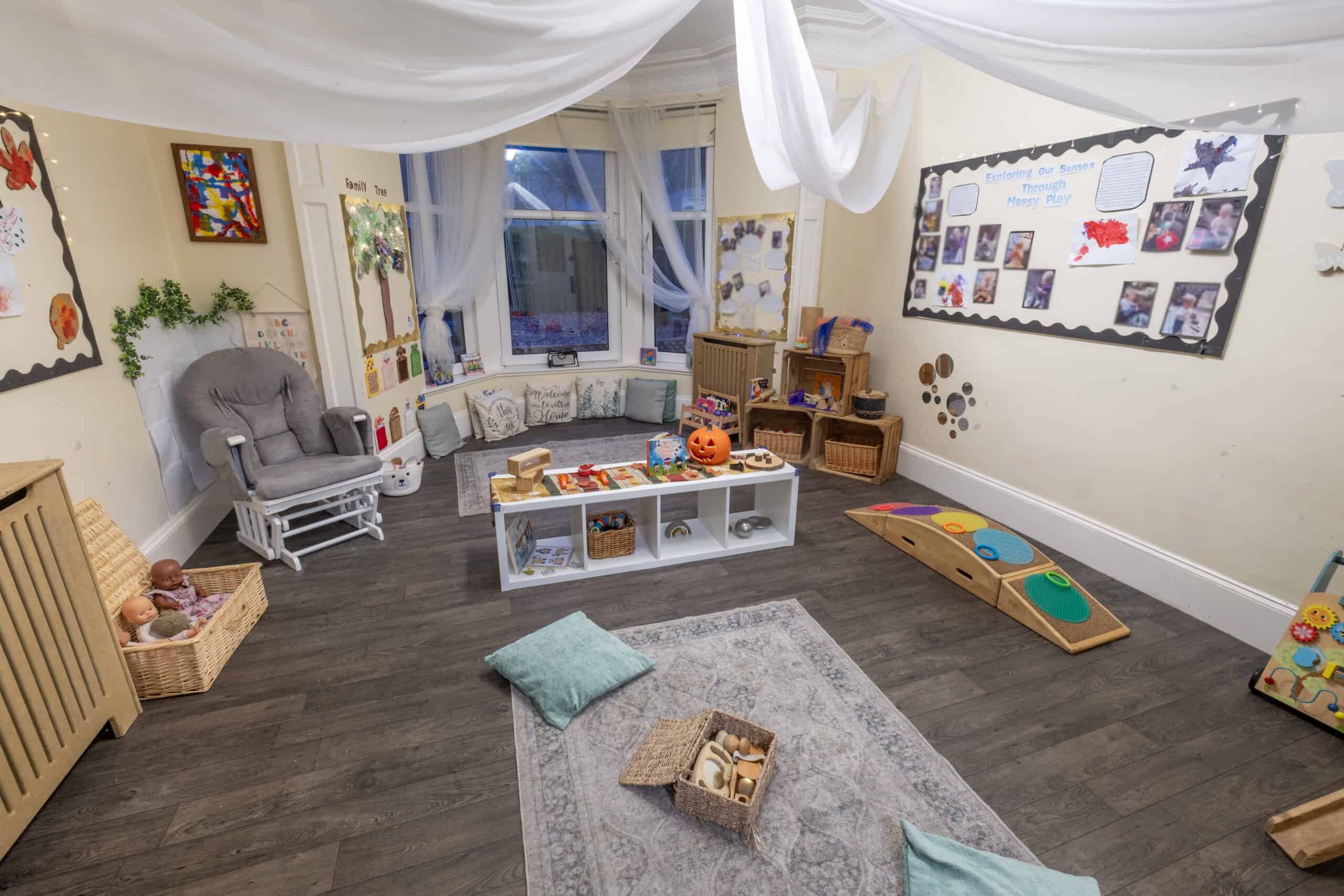 Bright, cosy indoor childcare playroom with toys, soft cushions, and educational displays, ideal for early childhood development at Thrive Childcare.