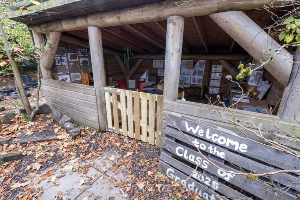 Bright outdoor learning space at Thrive Childcare, featuring a wooden classroom shelter for early childhood education and outdoor activities in a natural setting.