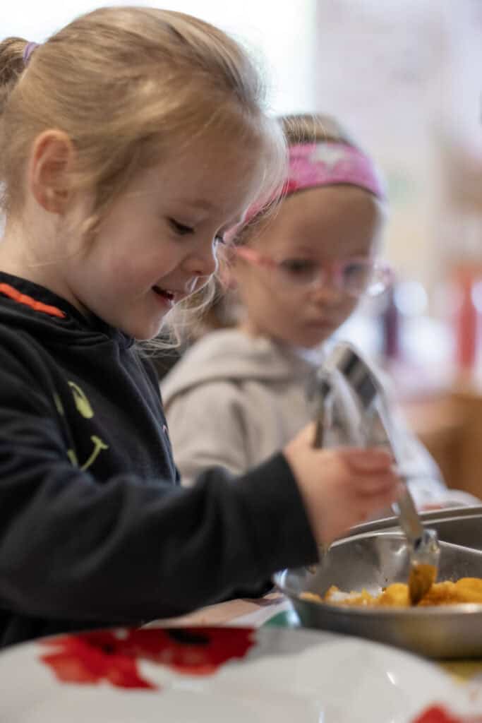 Children enjoying healthy meal at Thrive Childcare, engaging in nutritious eating and social interaction, promoting early development, balanced diet, and community.