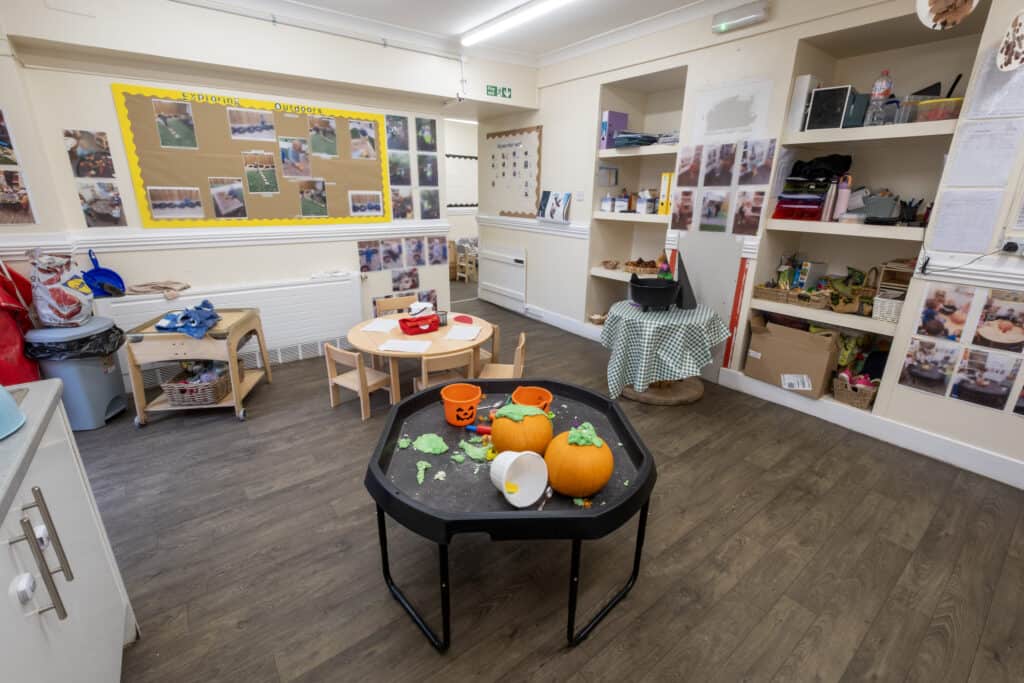 Pumpkin-shaped Halloween decorations with green slime on a black table in a colourful childcare indoor play area showcasing Thrive Childcare facilities for early childhood education.