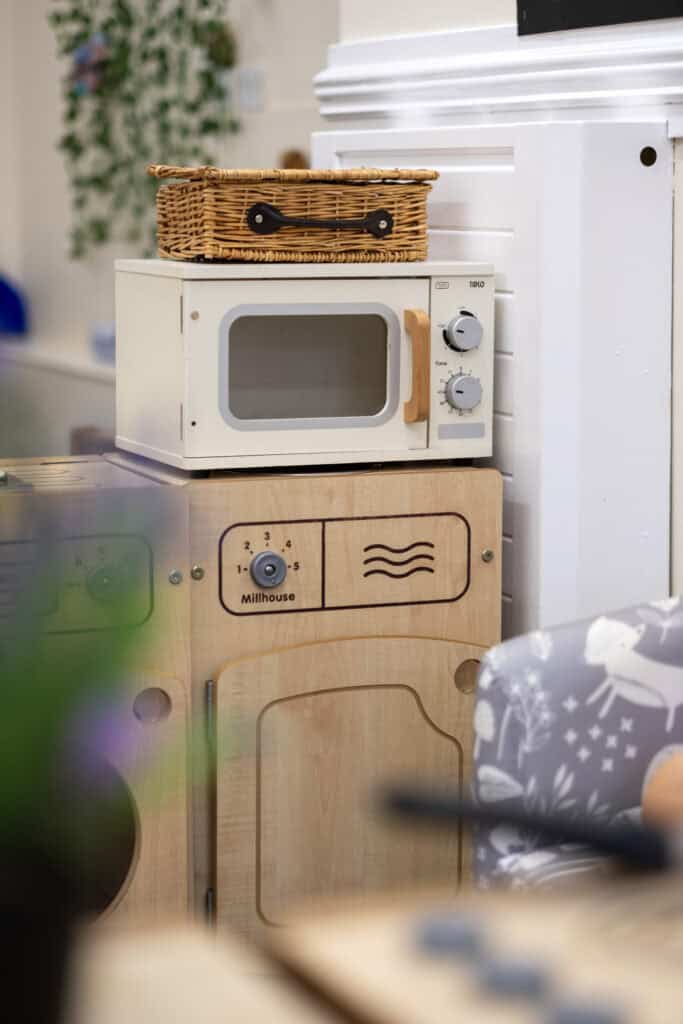 Miniature toy microwave and oven set for children's imaginative play at Thrive Childcare, promoting creative learning and developmental skills in a caring environment.