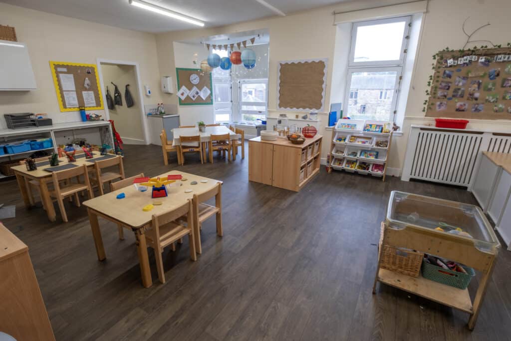 Bright and welcoming child care classroom at Thrive Childcare featuring colourful tables, educational toys, and learning materials to promote early childhood development and engagement.