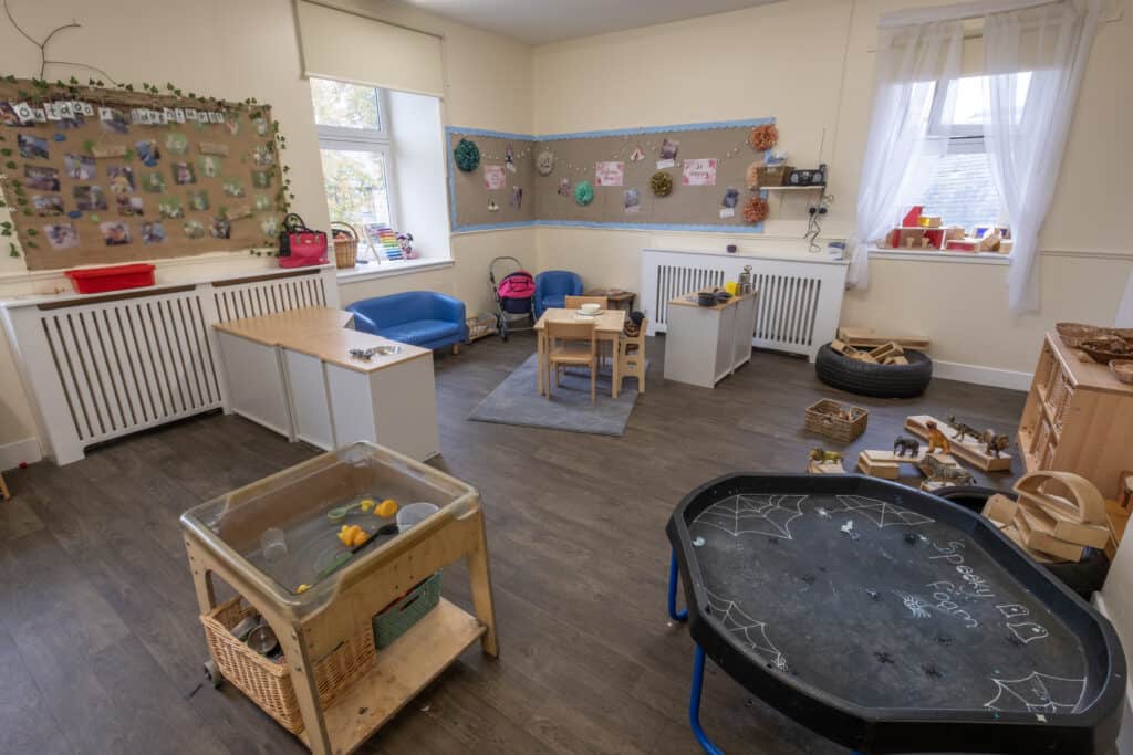 1. Bright childcare indoor playroom with toddler furniture, educational toys, and learning areas at Thrive Childcare, supporting early childhood development and safe environment.