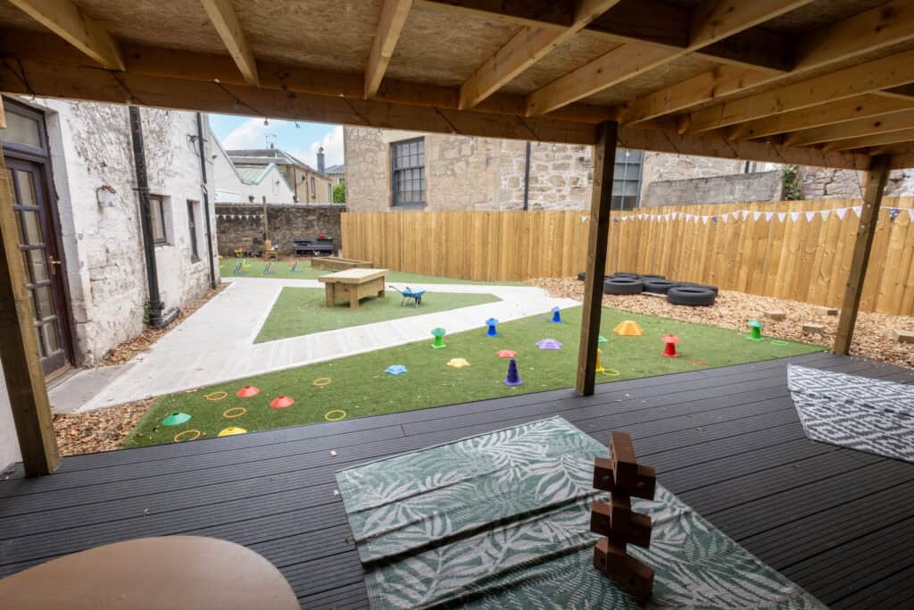 Bright outdoor play area at Thrive Childcare with colourful toys, sensory equipment, and safe space for children to learn and explore in a secure environment. Perfect for early childhood development.