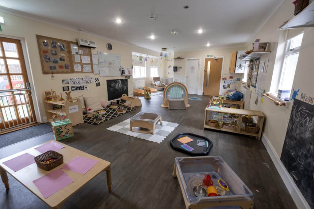 Bright and welcoming indoor childcare playroom with age-appropriate toys, sensory areas, and learning stations at Thrive Childcare for early childhood development.