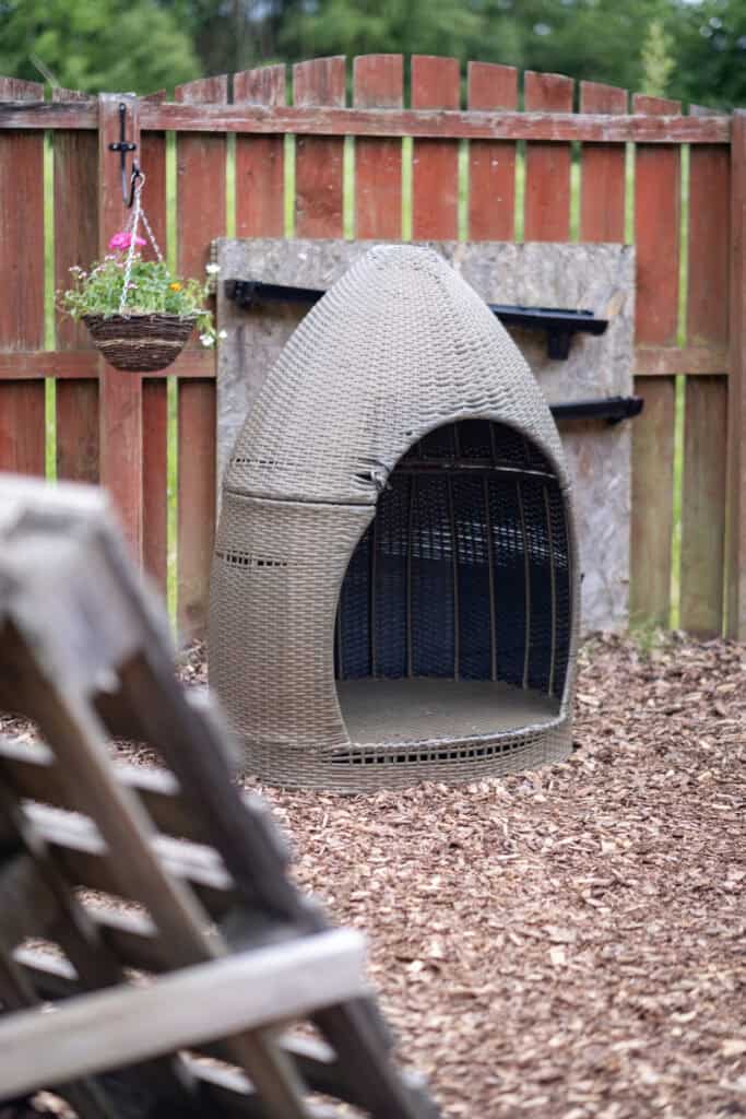 A cosy outdoor child-safe hideaway with a woven shell, perfect for imaginative play and relaxation at Thrive Childcare.