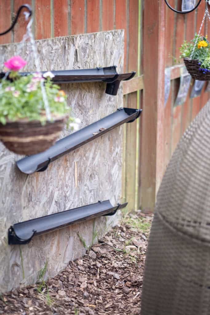 Bright outdoor play area with flower baskets and weatherproof gutters at Thrive Childcare, designed for engaging children in nature-inspired activities and fostering outdoor learning.