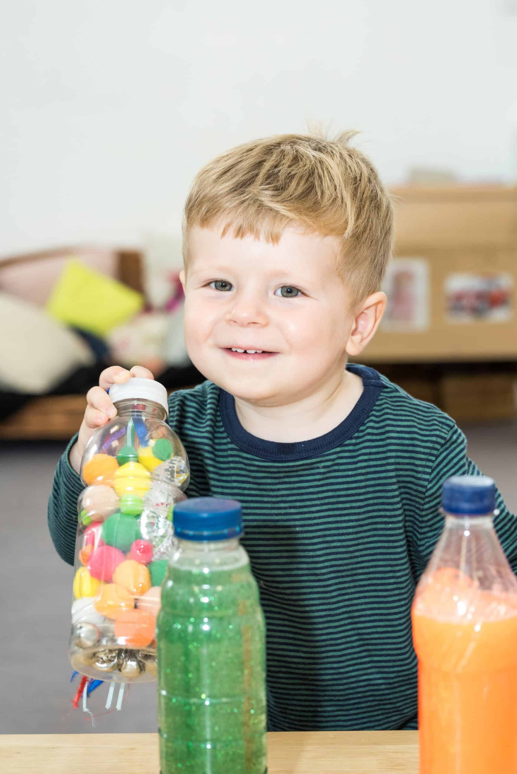 1. Smiling young boy engaging in playful learning activity at Thrive Childcare, showcasing kids' educational and social development in a nurturing environment.