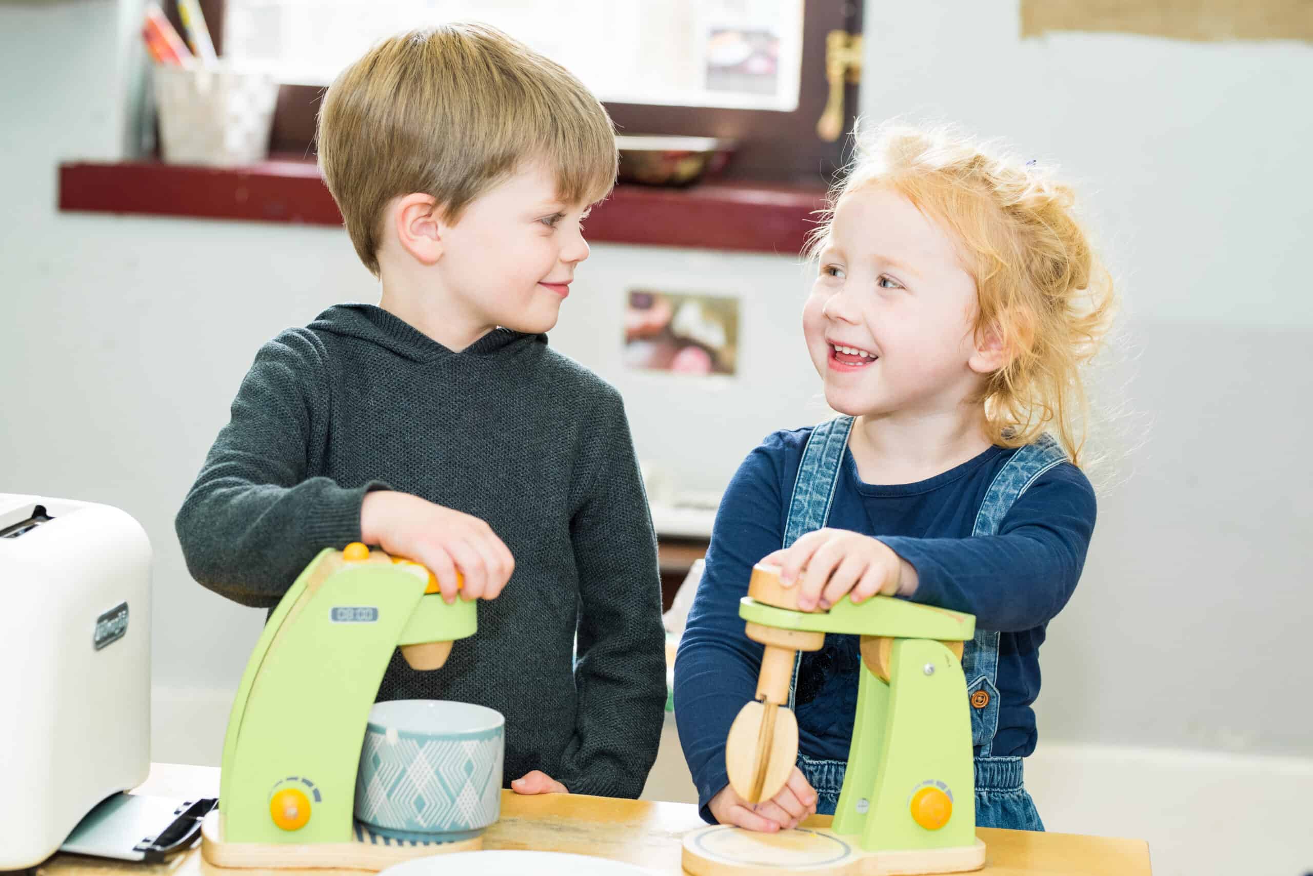 Childrens smiling and playing with toys at Thrive Childcare, early childhood education, and fun learning environment for kids in a friendly nursery setting.