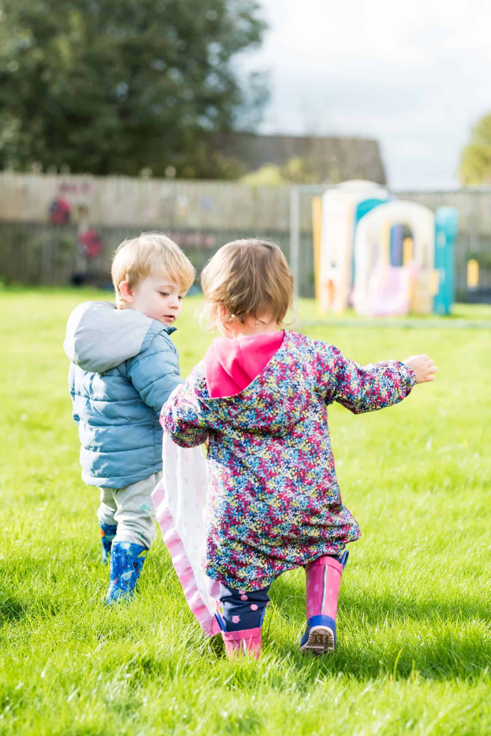 Playful children exploring outdoor playground at Thrive Childcare, fostering early childhood development and social skills. Bright, safe environment for young kids to learn and have fun.