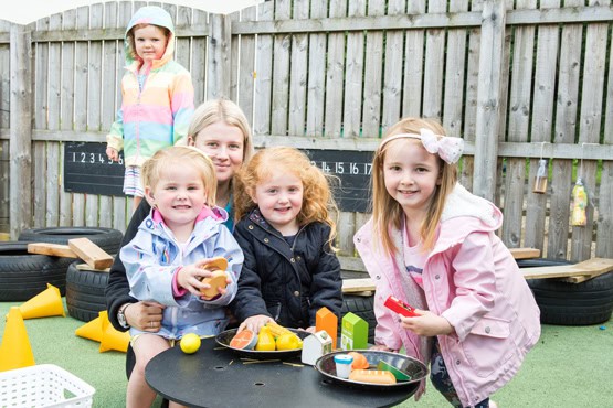 Bright preschool children playing outdoors with toys at Thrive Childcare, encouraging early learning and social skills in a safe, nurturing environment.