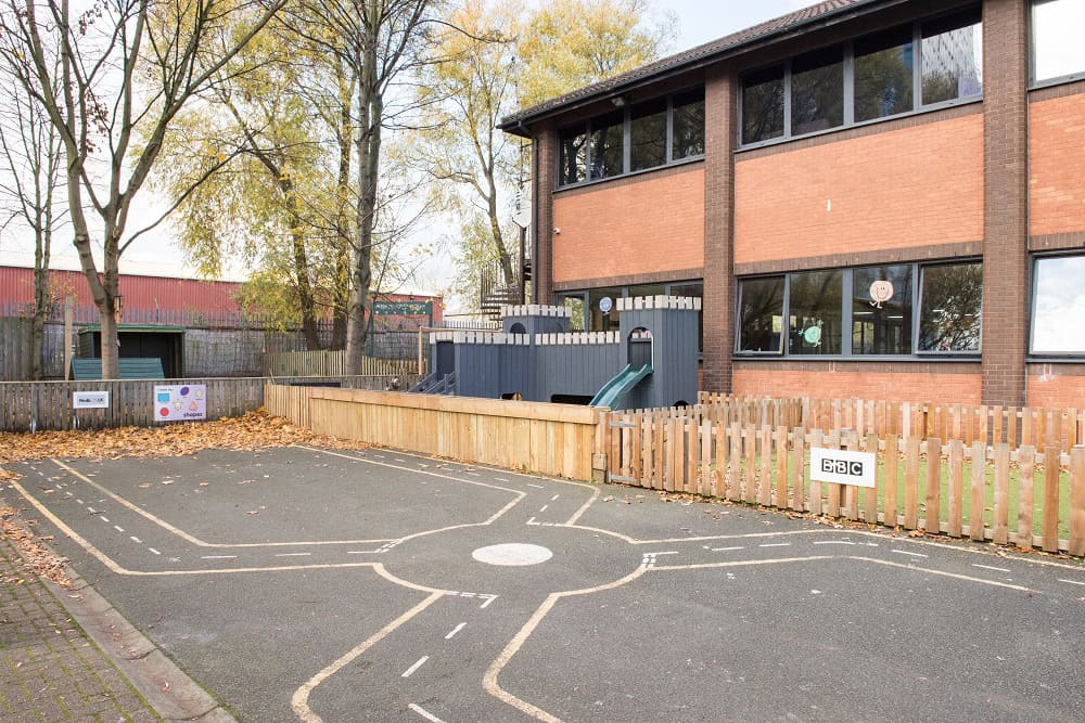 Bright outdoor playground at Thrive Childcare with safe play area, colourful markings, and secure fencing, providing a stimulating environment for early childhood development.
