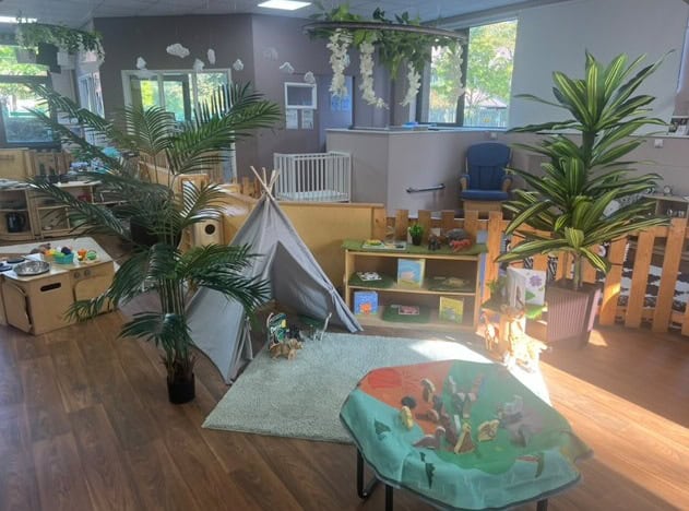 Bright indoor childcare play area with plants, toys, and a tepee tent, promoting a safe and engaging environment for young children at Thrive Childcare.