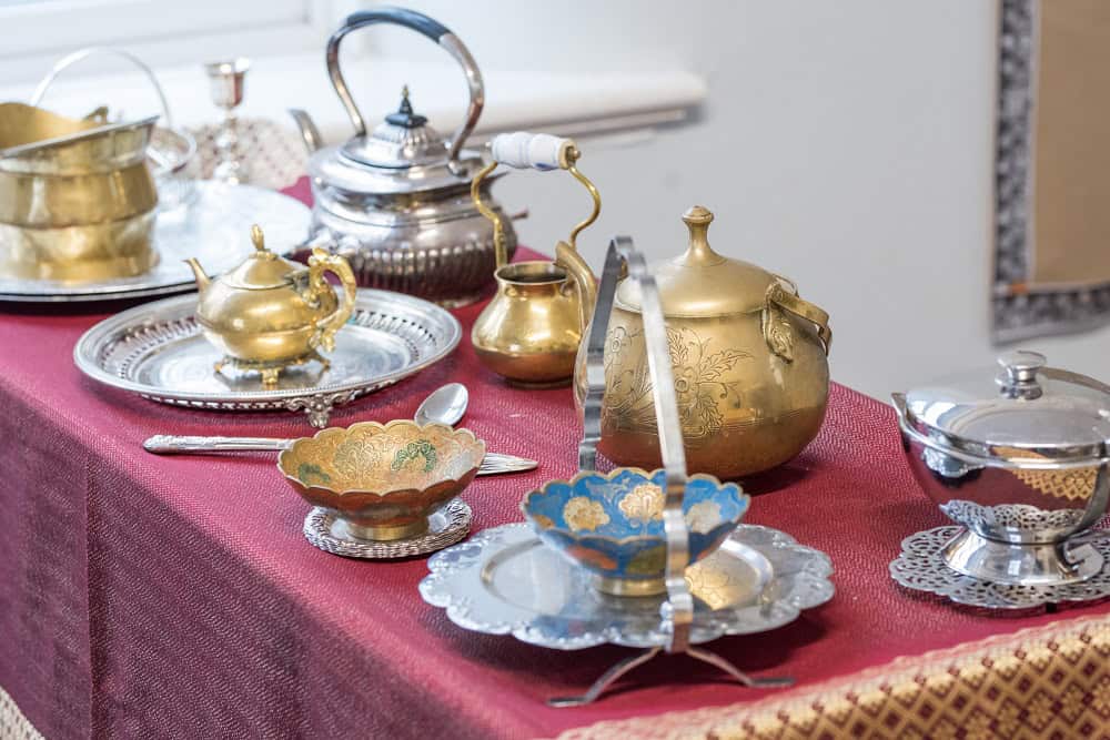 1. Vintage silver and gold tea set displayed on a red tablecloth, ideal for early childhood education and creative play activities.