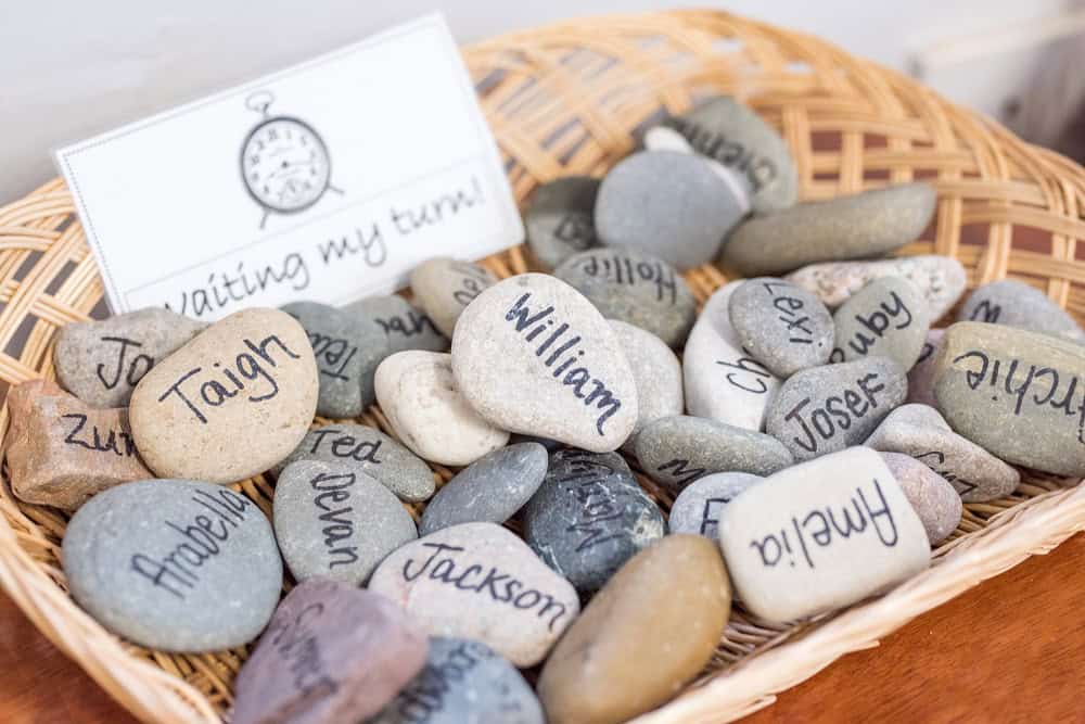 Personalised painted stones with children’s names, used as educational tools or keepsakes in Thrive Childcare settings in the UK.