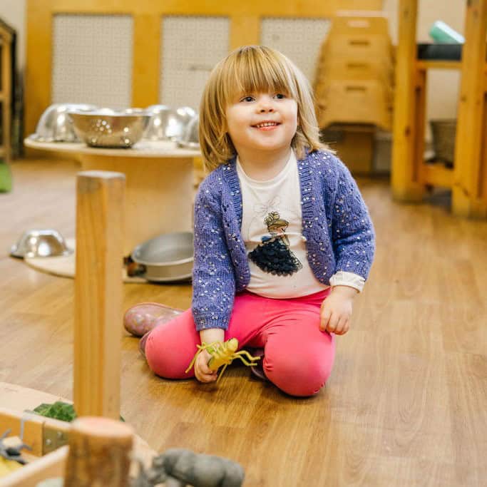 Young girl playing in a child-friendly nursery setting at Thrive Childcare, engaging in educational and outdoor activities, promoting early childhood development and care.