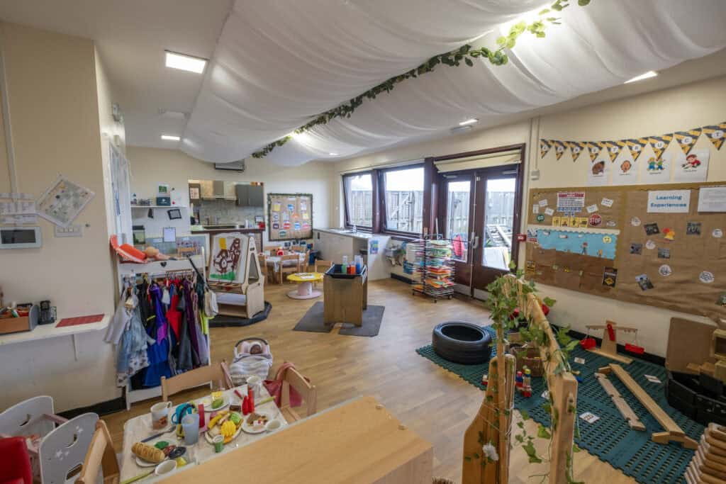 Bright indoor childcare classroom at Thrive Childcare with learning areas, play stations, colourful educational displays, and natural light; dedicated to early childhood development and childcare services.