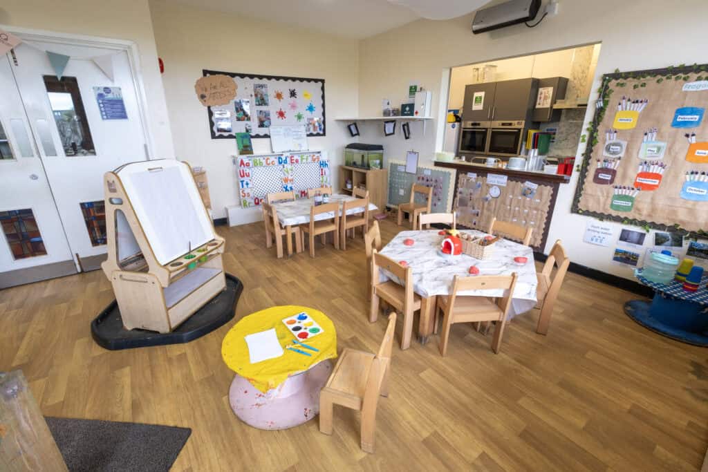 Colourful and inviting childcare classroom at Thrive Childcare with child-friendly tables, educational posters, art displays, and play areas promoting early learning and development.