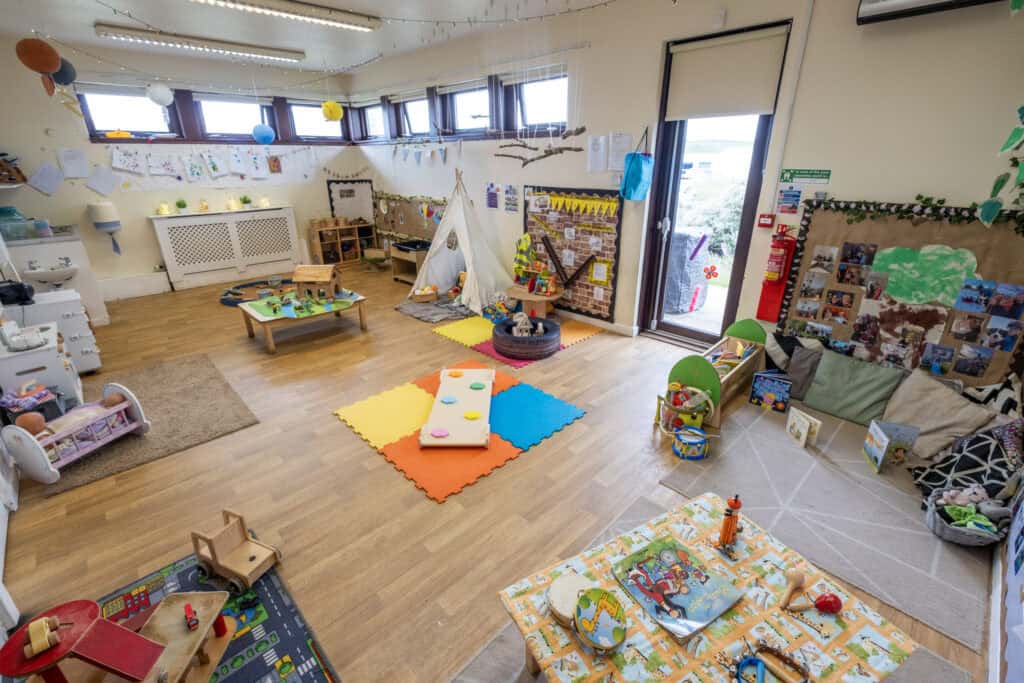 Bright and inviting childcare classroom with toys, play areas, and educational displays at Thrive Childcare, promoting a safe and engaging environment for young children’s development and learning.