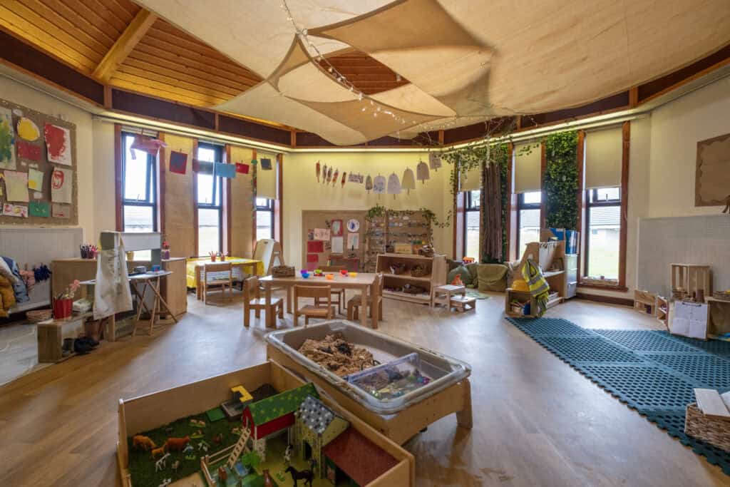 Bright and welcoming early years childcare classroom at Thrive Childcare featuring educational toys, sensory play areas, and colourful artwork to support child development and learning.