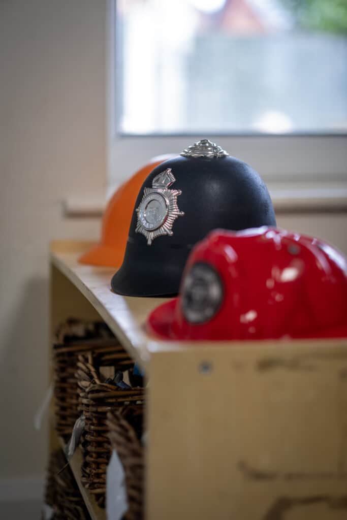Police helmets for children with police badge designs, part of playful learning activities at Thrive Childcare to promote safety awareness.