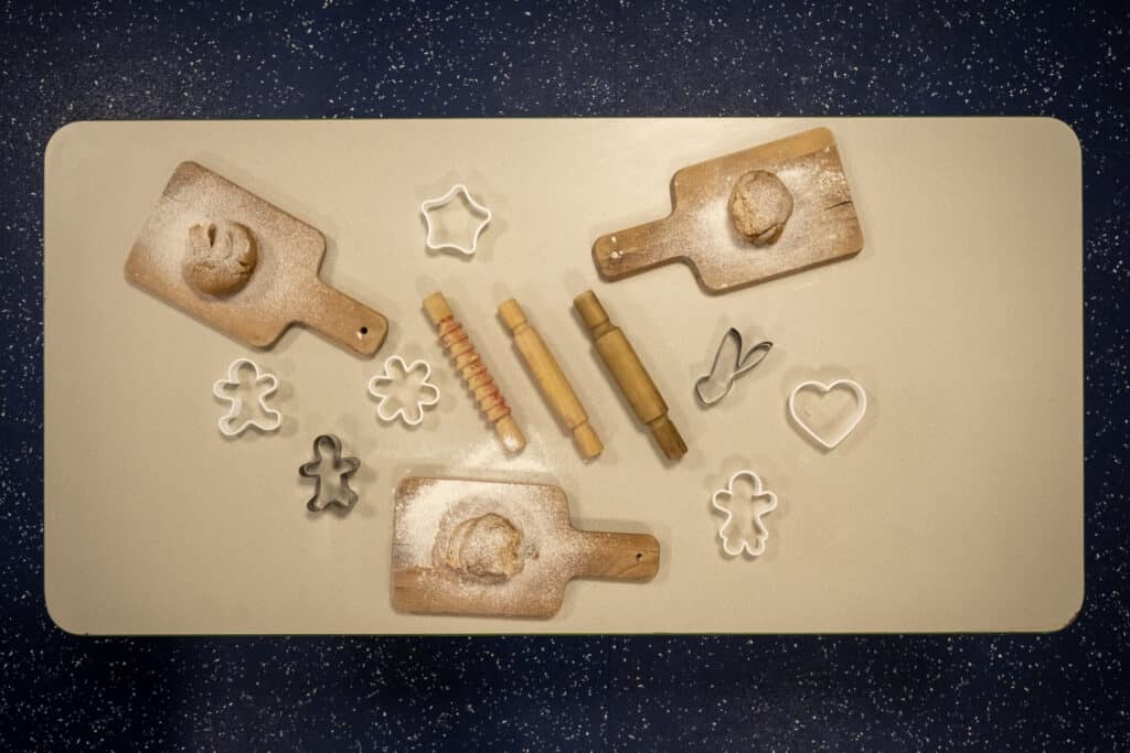 Freshly baked cookies and cookie cutters on a baking tray, perfect for children's activities at Thrive Childcare in the UK. Engaging and fun baking experience for kids.