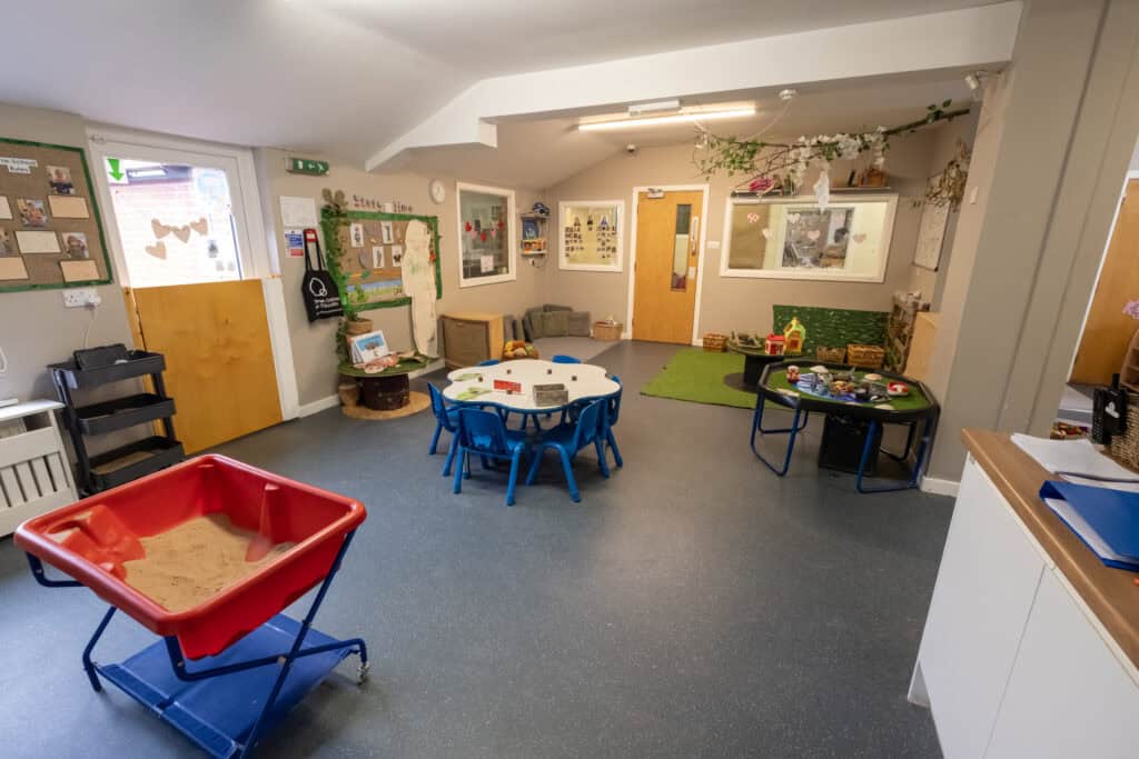 Bright and welcoming childcare classroom at Thrive Childcare with play areas, sensory table, toddler-friendly furniture, and engaging educational displays, designed for early childhood development and learning.
