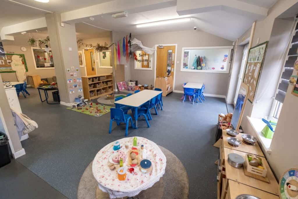Bright, welcoming Thrive Childcare indoor playroom with colourful toys, activity tables, and educational play areas for early childhood development and safe learning environments.