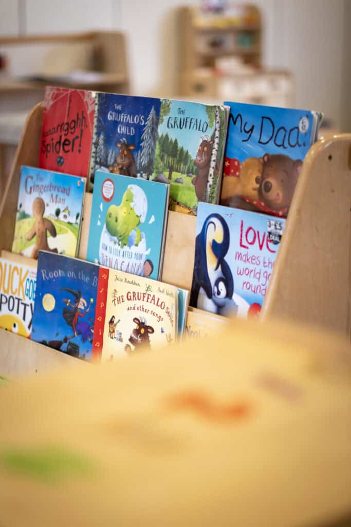 Bright children's picture books on display in a friendly nursery classroom, promoting early literacy, learning, and discovery for young children at Thrive Childcare.