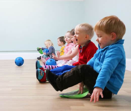 Children sitting on the floor and playing during a daycare activity at Thrive Childcare, promoting early childhood development and social skills in a nurturing environment.