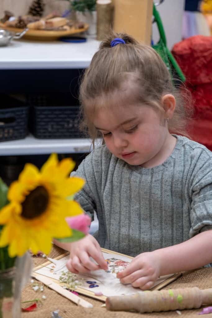 1. Young girl engaging in arts and crafts activities at Thrive Childcare, promoting creativity and developmental skills in a nurturing environment.