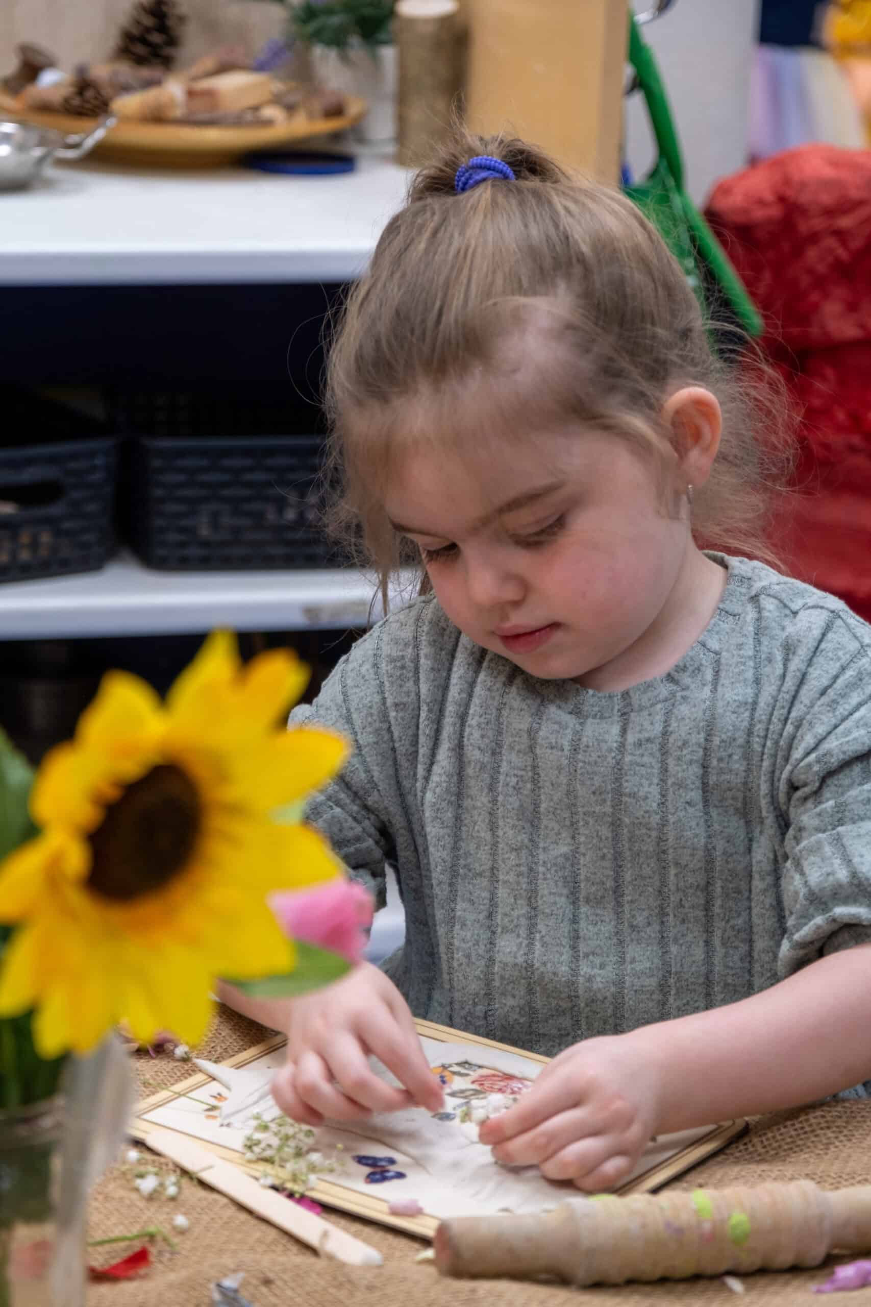 1. Young girl engaging in arts and crafts activities at Thrive Childcare, promoting creativity and developmental skills in a nurturing environment.