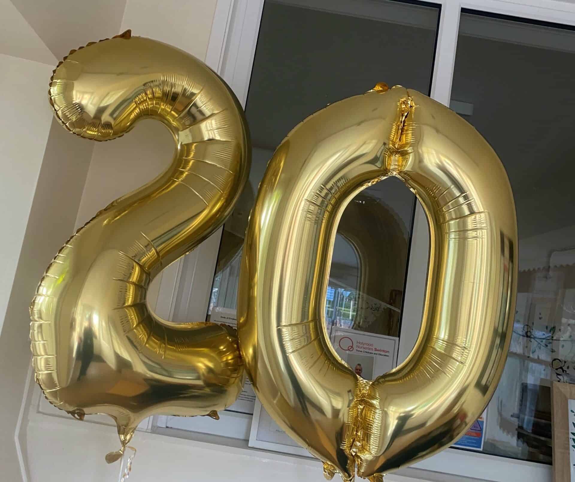 2 large gold foil balloons shaped as the number 20, celebrating a special anniversary at Thrive Childcare. Perfect for capturing memorable moments and enhancing celebration events.