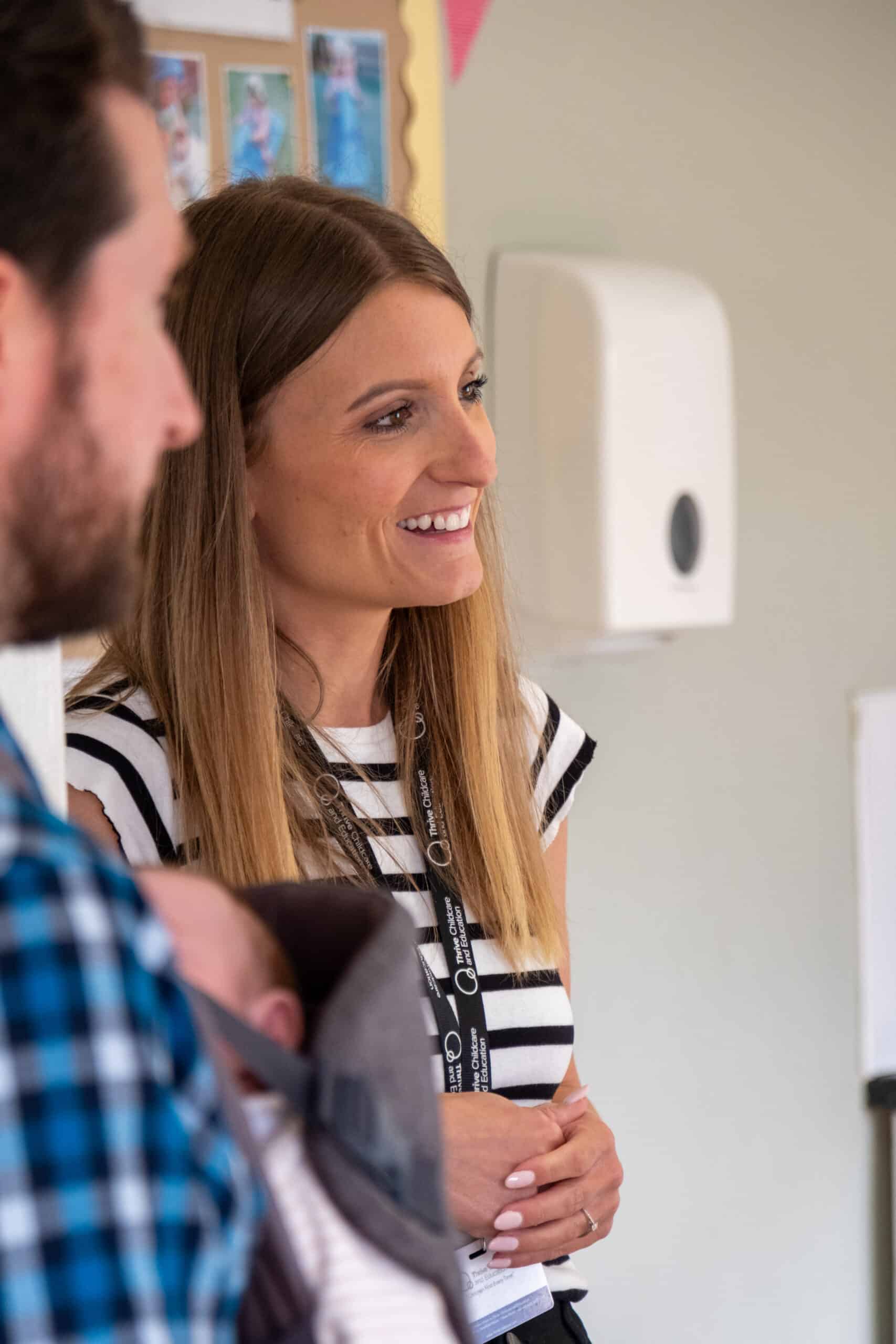 Friendly childcare staff at Thrive Childcare centre engaging with parents, providing safe and nurturing early childhood education and development services for children.