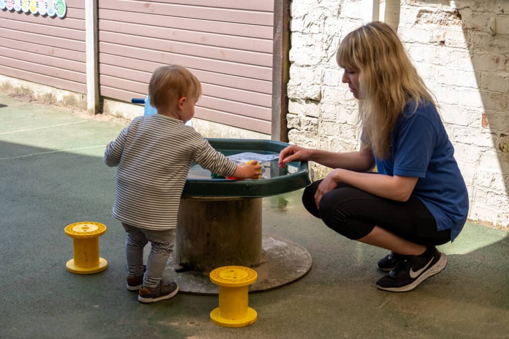 A young child and caregiving professional playing together outside at Thrive Childcare, fostering developmental growth and social skills in a safe, nurturing environment.