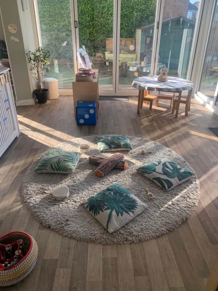 Soft play area with cushions and plush logs in a bright indoor nursery setting, promoting children's play, relaxation, and sensory development at Thrive Childcare.