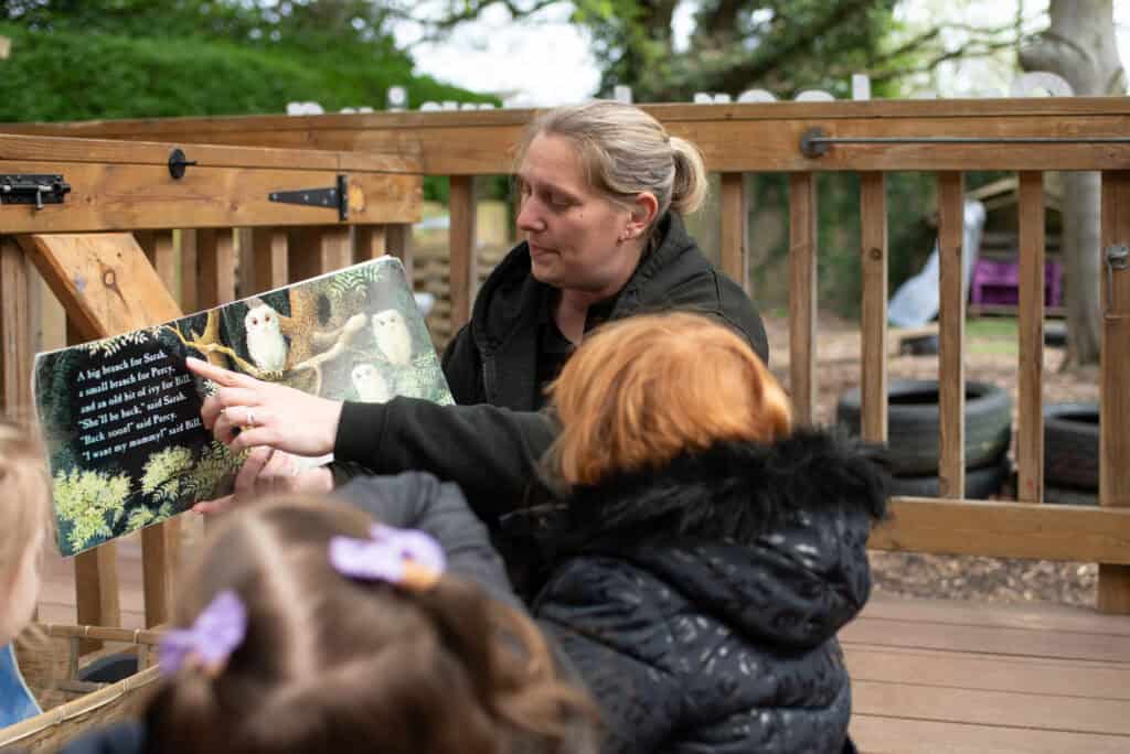 Owl reading session outdoors with children at Thrive Childcare, fostering early literacy and nature exploration. Engaging storytime in a natural setting supports children's learning and development.