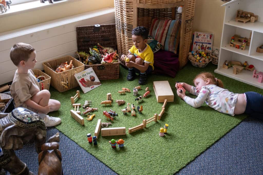 Vibrant indoor play area at Thrive Childcare with young children engaging in imaginative play with toy animals and figures. Bright, welcoming space designed to promote early childhood development and creativity.