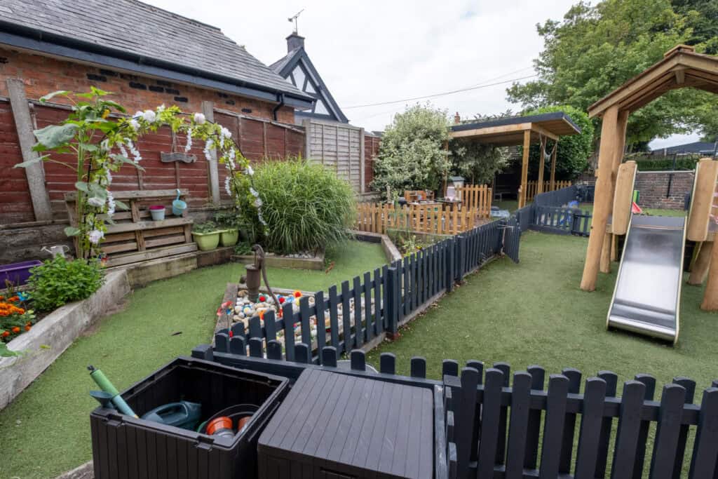 Colourful and safe outdoor playground at Thrive Childcare with slide, sandbox, and garden area for children’s play and exploration. Ideal environment for early childhood development.