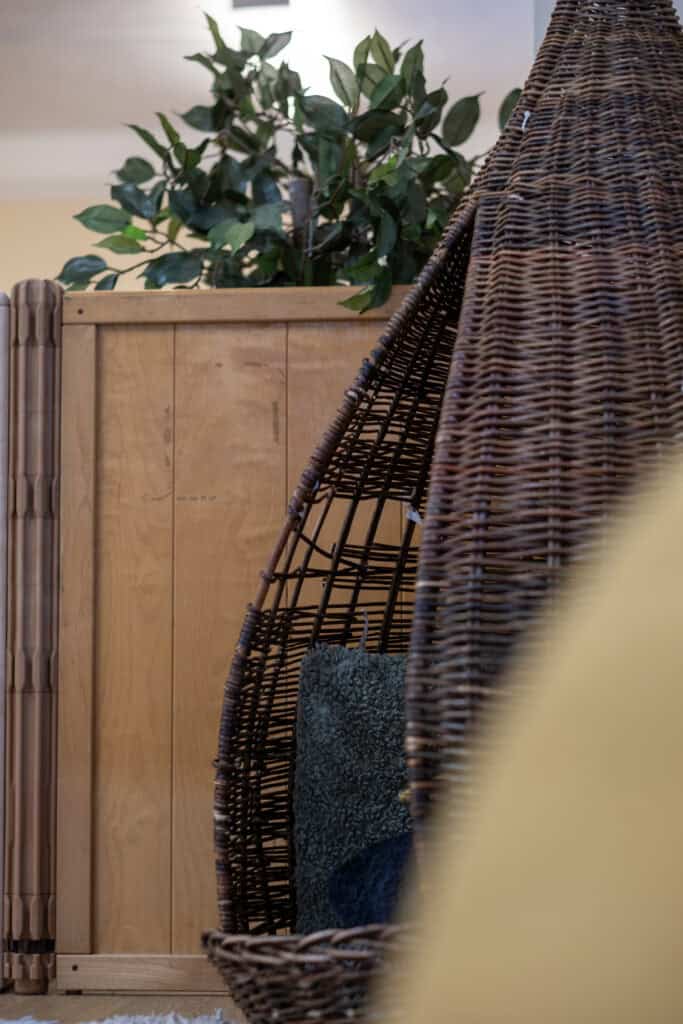 1. Wicker children’s egg chair with cozy cushion, in a bright childcare setting, enhancing comfort for kids.