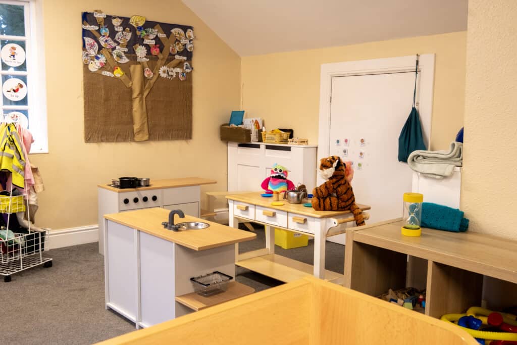 Soft play area and children's toys at Thrive Childcare with wooden tables, educational decor, and cosy environment for early childhood development and learning.