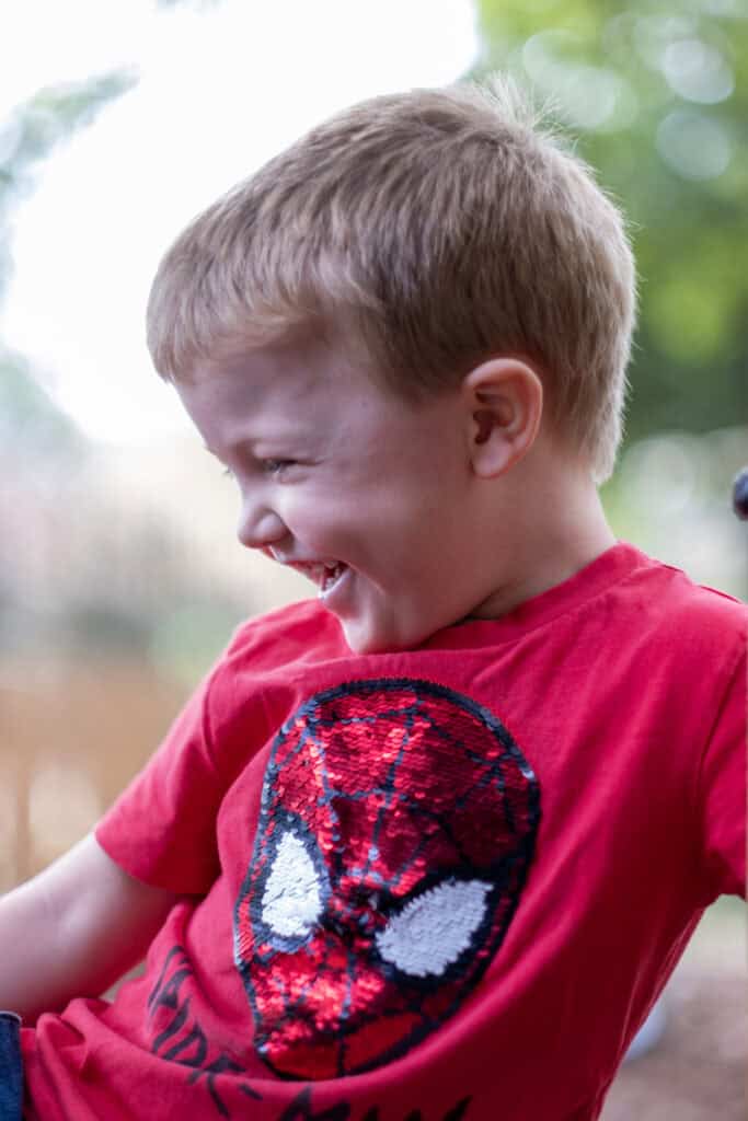 Bright young boy enjoying outdoor play at Thrive Childcare, showcasing engaging childcare services with a focus on child happiness and development.