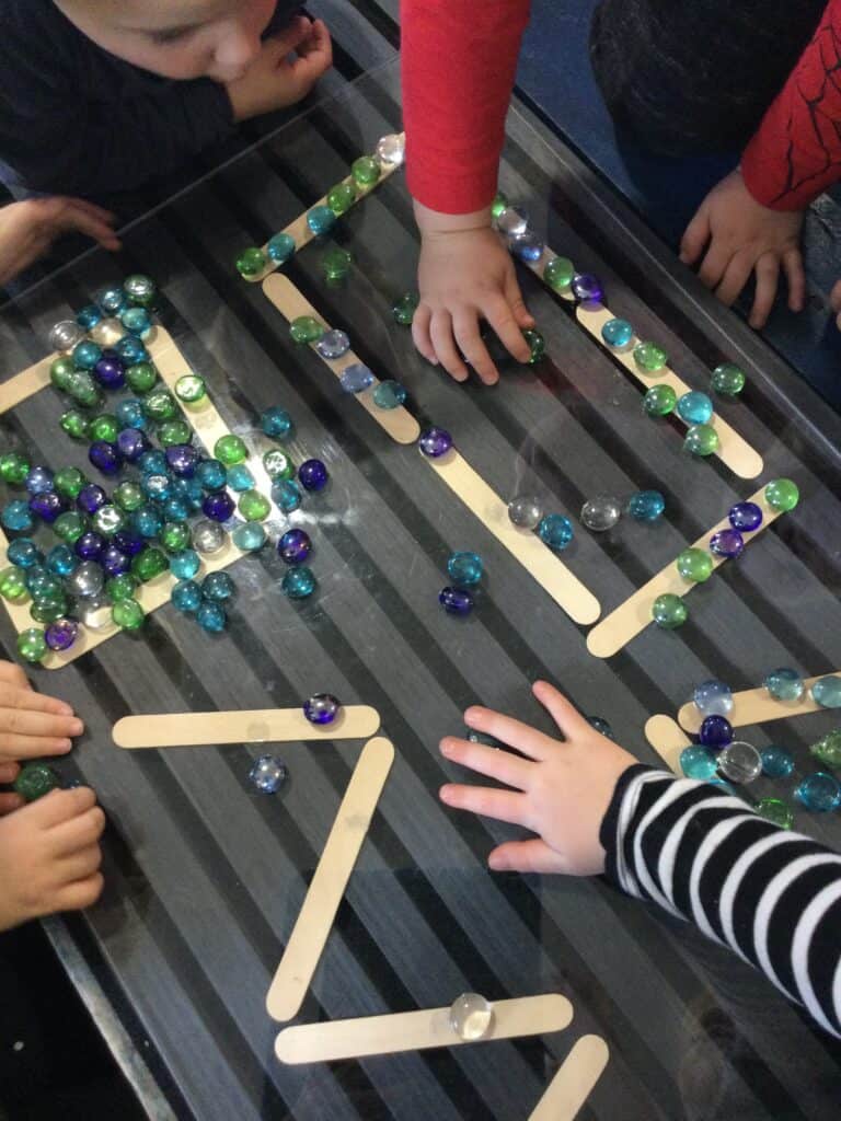 Bright children engaging in educational marble counting activity at Thrive Childcare, promoting early learning and fine motor skills in a nurturing environment.