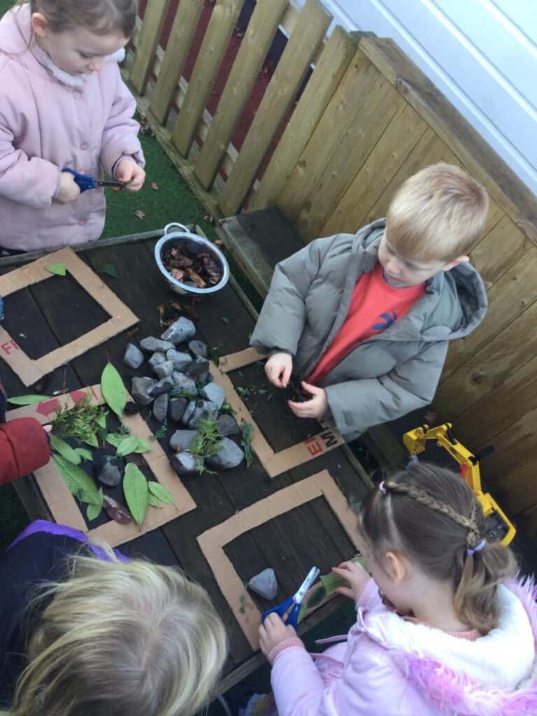 Bright preschool children engaging in outdoor nature activities at Thrive Childcare, exploring rocks, leaves, and plants in a safe, nurturing environment promoting early childhood education and development.